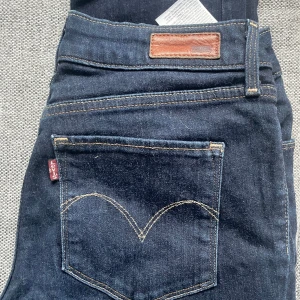 Mörkblå jeans från Levi's - Snygga mörkblå jeans från Levi's med klassisk femficksdesign och dragkedja. Perfekta för en avslappnad stil. De är lågmidjade.  och är tillverkade i slitstarkt denim.
