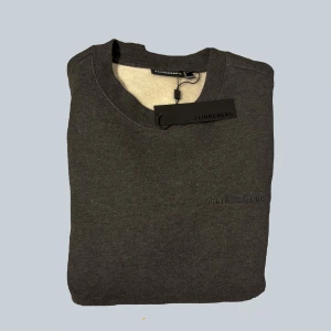 Ny mörkgrå tröja från J.Lindeberg - Säljer en helt ny mörkgrå tröja från J.Lindeberg. Tröjan har en broderad logotyp på bröstet. Lappar sitter kvar. Storlek M. Priset är ej hugget i sten, bara och höra av sig//Mvh Charlie