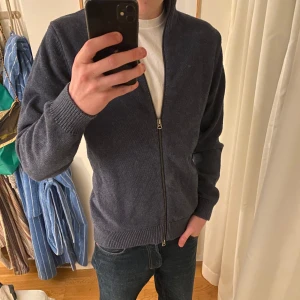 Blå hel zip - Säljer en stilren mörkblå kofta med dragkedja från dobber. Den har långa ärmar och ribbade muddar vid ärmslut och nederkant. Perfekt för kyligare dagar. Skriv om ni vill diskutera pris eller om ni har fler frågor!🙌