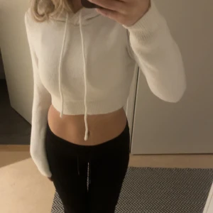 Vit croppad hoodie - Säljer en superfin vit croppad hoodie i stickat material. Den har långa ärmar och en mysig huva med dragsko. Perfekt för en avslappnad stil eller att mysa i hemma. Passar bra till både jeans och mjukisbyxor. 🧡 i storlek S från Zara 