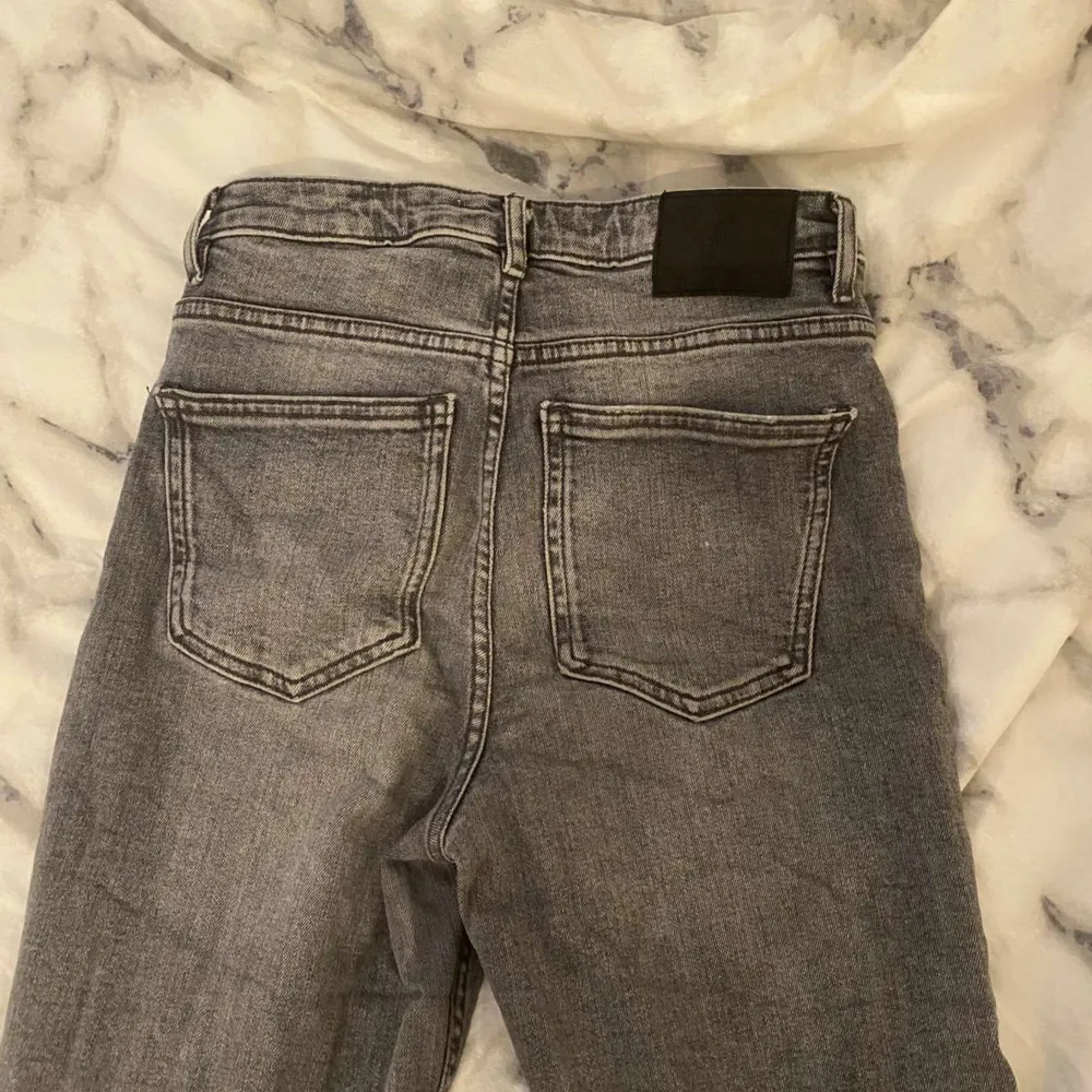 Säljer ett par grå bootcut jeans från Zara i storlek 36. De finns fickor fram, bak och hål på knäna. Skulle säga att de är i bra skick och har inga hål eller så utom att det finns små blekningsfläckar på höger bakben som syns på sista bilden. 💗. Jeans & Byxor.