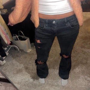 Low Waits svarta jeans  - Inerbenslängd uppsytt- 75, innerbenslängd utan uppsytt - 81, midjemått rakt över-37 men dom är väldigt stretchiga Säljer ett par jätte snygga svarta flare jeans från BDG Urban Outfitters. I jätte fint skick med slitningar 💕då dom va för långa sydde jag upp dom med 4 enkla stygn nertill ( se sista bild) men som sakt är det väldigt enkla stygn så man kan lätt sprätta upp och inte se någon skada! Jag är 162