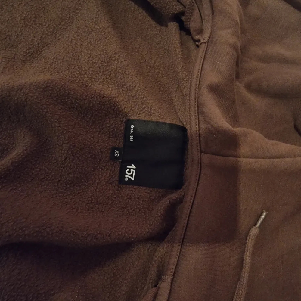 Mysig brun fleece hoodie från 157 i storlek XS. Perfekt för kyliga dagar med dragkedja och huva. Den är i bra skick och redo för nya äventyr. Passar perfekt för höst och vinter!. Tröjor & Koftor.