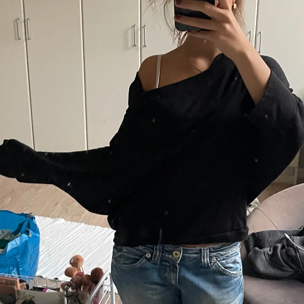 Säljer en snygg svart offshoulder tröja som är perfekt för både vardag och fest. Den har en lös passform och långa ärmar, vilket gör den superbekväm. Materialet känns mjukt och skönt mot huden. Passar perfekt till ett par jeans eller kjol för en stilren look.. Tröjor & Koftor.