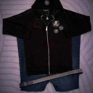 Svart hoodie med Scarface-tryck från Philipp Plein - INTE FASTA PRISET, TAR PRIS FÖRSLAG Säljer en svart hoodie från Philipp Plein med coola Scarface-motiv på baksidan och dödskalle-detaljer fram. Den har en dragkedja och är långärmad, perfekt för höst och vår. Grymt snygg och unik stil för dig som vill sticka ut! DEN ÄR ÄKTA, jag kan visa bevis om intresserad. ny pris är över 14,000 men priset kan diskuteras. Large men passar mer som medium