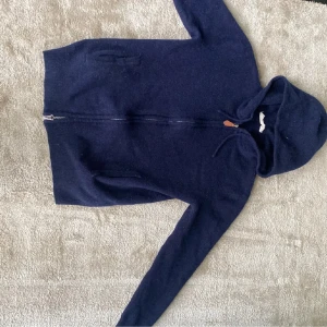 Mörkblå kashmir hoodie - Säljer denna skit snygga Kashmir zip hoodien i okej skick. Den har ett litet hål i armhålan som lätt går att laga. Storleken är XS och passar dig som är 160-170. Priset kan diskuteras. 