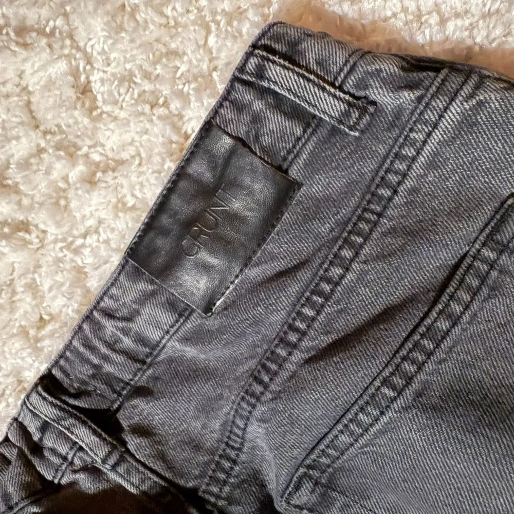 Säljer ett par grå jeans från Grunt i bra skick. De har en klassisk straight passform och är tillverkade i bomull. Perfekta för både vardag och fest. De har en knappgylf och fem fickor. Passar till alla säsonger!. Jeans & Byxor.