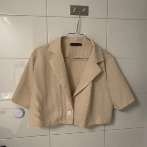 Topp / skjorta - Croppad skjorta/topp i polyester i fint skick, se närbild av mönster på bild 2!