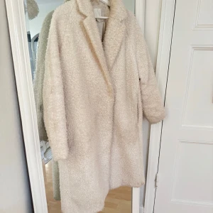 Beige teddyjacka - Supermysig beige teddyjacka i mycket bra skick. Perfekt för kalla höst- och vinterdagar. Jackan har en oversized passform och långa ärmar, vilket gör den både trendig och bekväm. Den är gjord av ett mjukt och fluffigt material som håller dig varm och stilren. Storlek M. Köpt från HM för 2 år sedan och inte använd sedan dess, 999kr köptes den för. 