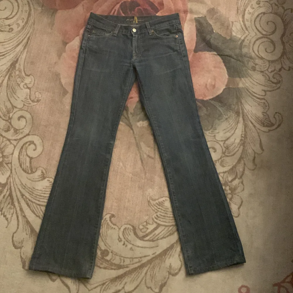 Säljer ett par snygga mörkblå bootcut jeans i bra skick. De har en klassisk femficksdesign och är perfekta för både vardag och fest. Jeansen är högmidjade och har en bekväm passform. Perfekta för höst och vår! Dom är också low rist. Jeans & Byxor.