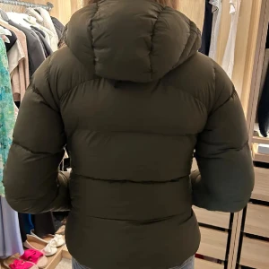 Grön pufferjacka från Sail Racing Säljer vidare!!!! - Säljer vidare en jacka jag köpt här på sidan! Dottern ångra sig tyvärr, så nu sälver vi vidare i exakt samma skick som när vi köpte! Säljer en snygg grön pufferjacka från Sail Racing i storlek XS. Jackan har en dragkedja framtill och en mysig huva. Perfekt för kyliga dagar och håller dig varm och stilren. Använd ett fåtal gånger, så den är i mycket bra skick. Passar perfekt till både vardag och utflykter! 