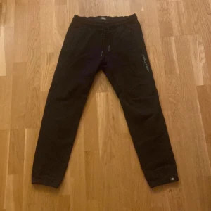 Svarta mjukisbyxor från Scotch & Soda - Säljer ett par svarta mjukisbyxor från Scotch & Soda i 152 12 år. Byxorna har en bekväm passform med snörning i midjan och är perfekta för en avslappnad stil. De är i mycket bra skick och passar perfekt för höst och vinter.