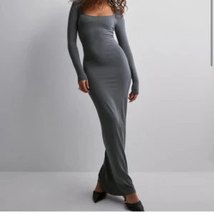 Grå långklänning - Snygg och elegant grå långklänning med tight passform. Klänningen har långa ärmar och en stilren design som passar perfekt för höst och vinter. Perfekt för både vardag och festliga tillfällen.