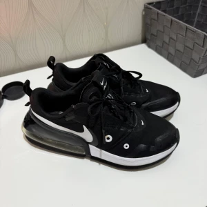 Svarta Nike sneakers med vit sula - Säljer ett par snygga svarta Nike sneakers med vit sula och synlig luftkudde i hälen. Skorna har snörning och är i mycket bra skick. Perfekta för både vardag och träning!