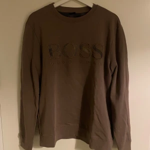 Brun sweatshirt från Hugo Boss - Säljer ovan Hugo Boss tröja i storlek L. Den är använde men är i fint skick & utan defekter!