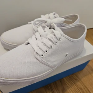 Vita sneakers från WA Action Sports - Snygga vita sneakers från WA Action Sports med klassisk snörning. Perfekta för en stilren look. Skorna har en enkel och tidlös design som passar till många olika outfits.