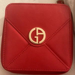 Röd sminkspegel från Giorgio Armani - (Vi diskuterar priset) Elegant röd sminkspegel från Giorgio Armani. Perfekt för att ha med i väskan för snabba touch-ups eller en låda för smycken
