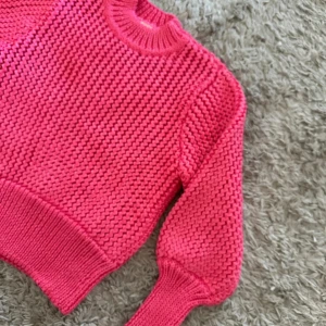 Rosa stickad tröja från H&M - Säljer en snygg rosa stickad tröja från H&M. Tröjan har en rund halsringning och långa ärmar, perfekt för kyligare dagar. Den är i en härlig rosa färg som verkligen poppar!