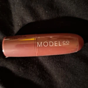 Läppstift i nyansen Rhubarb från ModelCo NY PLOMBERAD  - Snyggt läppstift från ModelCo i nyansen Rhubarb. Perfekt för en naturlig look med en hint av färg. Kompakt och lätt att ta med i väskan.