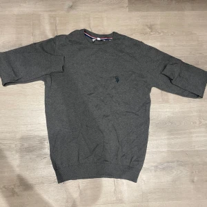 Grå stickad Sweatshirt från US Polo Assn - En fantastiskt snygg tröja som jag tyvärr knappt använt då den inte riktigt passar! Tänkte att jag skulle växa i den men då plånboken svider så måste den tyvärr säljas…
