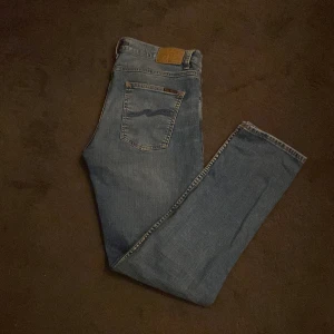 Nudie grim trim  - Säljer ett par klassiska blå jeans från Nudie Jeans. Modell grim trim. De har en snygg tvätt. Storlek w 33 L 32.  Använda 3 gånger bara. Skick 10/10. Nypris 1500. Har du frågor våga skriva!