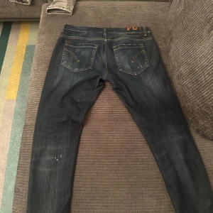 Dondup jeans - Snygga blå jeans från Dondup med en klassisk femficksdesign. De har en lätt tvättad look och är perfekta för en avslappnad stil. Passformen är skinny och de har en knappgylf. Modellen på jeansen är George