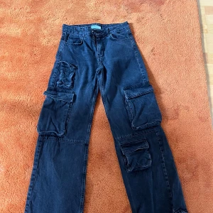 Svarta cargobyxor från Bershka - Snygga svarta cargobyxor från Bershka med flera praktiska fickor. Byxorna har en loose passform. Säljer eftersom de inte är min stil