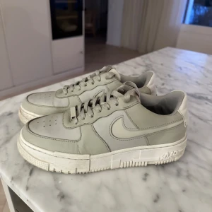 Nike Air Force i beige - Säljer ett par Nike Air Force sneakers i beige färg. Skorna har en snygg sula och snörning. 