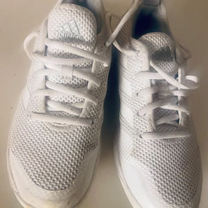 Vita sneakers från Adidas - stl 36 1/3 - Snygga vita sneakers från Adidas med klassisk design och snörning. Skorna har en stickad ovandel och en bekväm sula, perfekt för vardagsbruk.