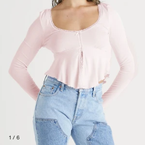 Rosa långärmad topp med spetsdetaljer - Säljer en superfin rosa långärmad topp med spetsdetaljer längs halsringningen och framtill. Toppen är croppad och har en söt liten rosett i mitten. Säljer eftersom den aldrig kommit till användning så den är som gott som ny💕