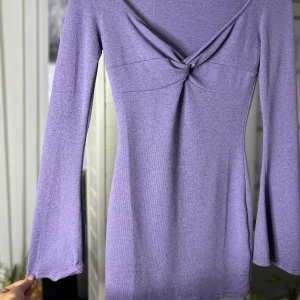 Lila klänning från Shein - Säljer en superfin lila klänning från Shein. Den har en snygg knutdetalj framtill och långa ärmar. Perfekt för både vardag och fest! 💜