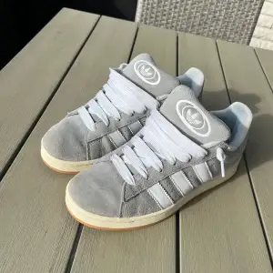 Ett par snygga gråa adidas campus!! Skick 9/10. Jag använde dom i våras några gånger väll behandlade. Har dock blivit blå färg på insidan av skon på bild 4 på grund av mina jeans som färga av sig. Tveka inte om att höra av dig om någon fundering!!