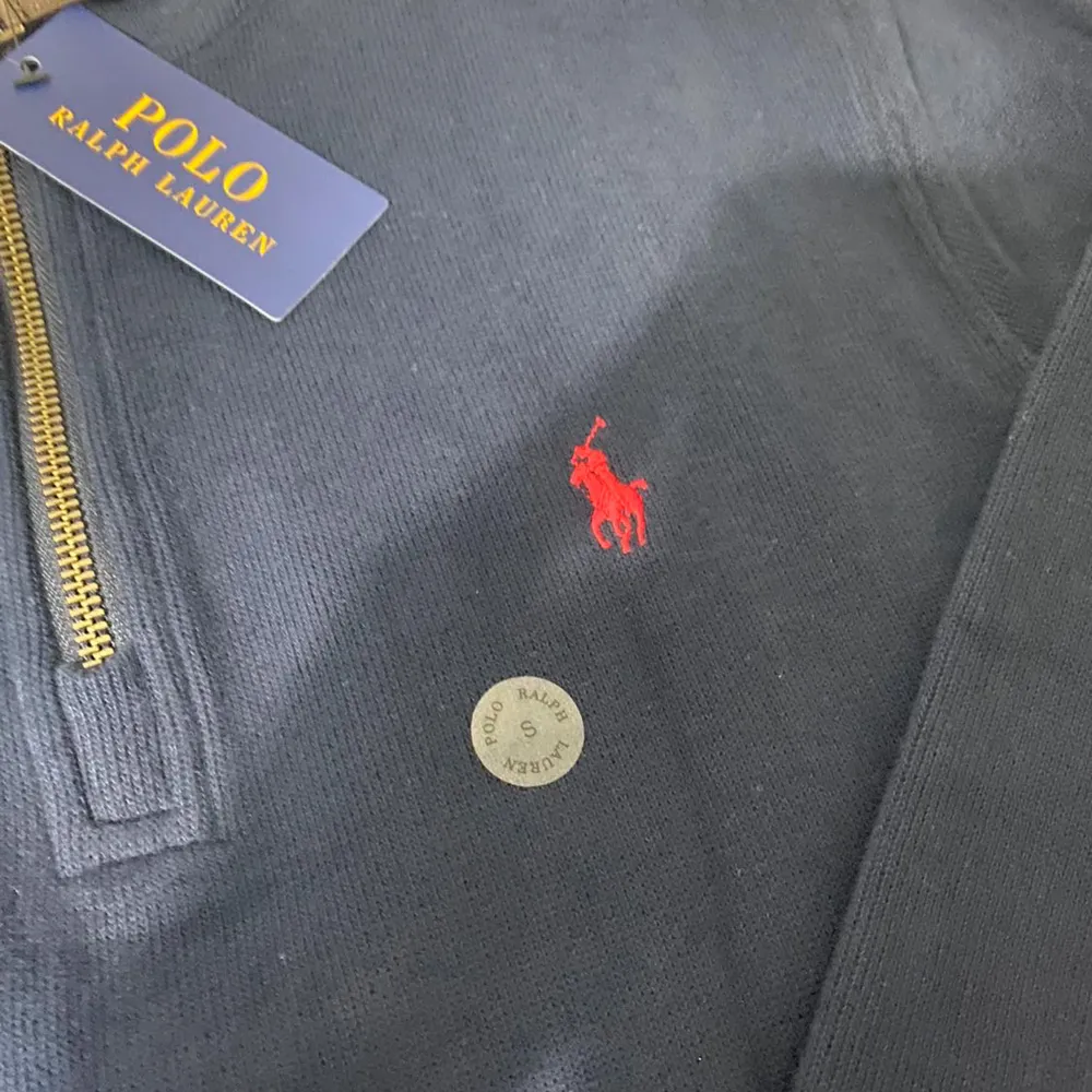 Säljer en snygg mörkblå tröja från Polo Ralph Lauren. Den har en dragkedja vid halsen och det klassiska röda Polo-logotypen på bröstet. Perfekt för både vardag och lite finare tillfällen. Tröjan är i nyskick och redo att bäras! Priset kan diskuteras. Tröjor & Koftor.