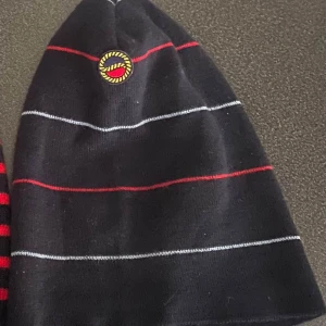 Busnel Mössa - Mörkblå Busnel mössa med röda och ljusblå  ränder.