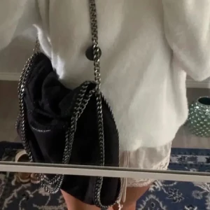 Jättefin Stella McCartney liknande väska ✨🩷 - Säljer en jättesnygg svart väska som ser likandan ut som en Stella McCartney ända skillnaden är att den inte har märket ingraverat ✨ Väskan har en stilren design och är perfekt för både vardag och fest och passar väldigt bra in i Stockholmsstilen. Den är i mycket bra skick och har en praktisk storlek för alla dina nödvändigheter och säljer denna då jag aldrig använder den🩷