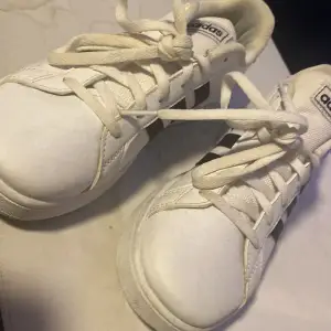 Säljer ett par klassiska vita Adidas sneakers i bra skick. De har de ikoniska svarta ränderna på sidan och snörning framtill. Perfekta för vardagsbruk och passar till nästan allt. Sköna och stilrena, ett måste i garderoben! Har nästan aldrig används, kan snöra dem snyggare ifall någon vill! Dem kostar att köpa 375 kr men jag säljer för endast 200kr det är ett VÄLDIGT bra kap enligt mig:)