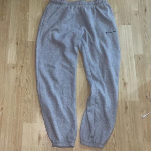 Grå mjukisbyxor från Champion - Säljer ett par grå mjukisbyxor från Champion i bra skick. De är superbekväma med elastisk midja och muddar vid bensluten. Perfekta för chill dagar hemma eller en snabb tur till affären. 🩶