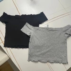 Svart och grå offshoulder topp - Två snygga offshoulder toppar i svart och grått, med vågig kantdetalj. 