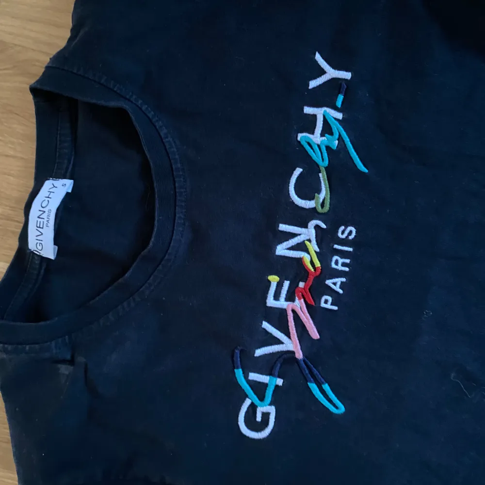 Säljer en  svart t-shirt från Givenchy med färgglatt broderat logotyp på framsidan. Bra skick, använd fåtal gånger . T-shirts.