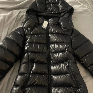 Svart pufferjacka med huva - Säljer en snygg svart pufferjacka i nytt skick. Den är perfekt för vintern . Den är helt slutsåld så därav priset !!! Den är storlek L men passar även m ❤️❤️❤️❤️Skriv vid mer frågor 