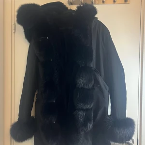 Svart parkajacka - Säljer en snygg svart parkajacka, ärmslut och längs med dragkedjan. Perfekt för kalla vinterdagar! Jackan har en långärmad design och är både stilren och varm. Passar perfekt för vintern, bra skick köpt för 5000 säljer denna för 1500 vill få den såld då den inte används man kan buda ner oxå.💕