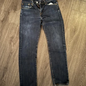 Mörkblå jeansbyxor - Säljer ett par klassiska mörkblå Levis jeans i bra skick. De har en straight passform och är perfekta för både vardag och fest. Byxorna har fem fickor och en knappgylf. Perfekt för höst och vår!
