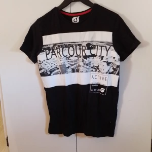 Svart T-shirt Med Tryck - Svart T-shirt med tryck från woxo i storlek 158/164.  Katt finns i hemmet