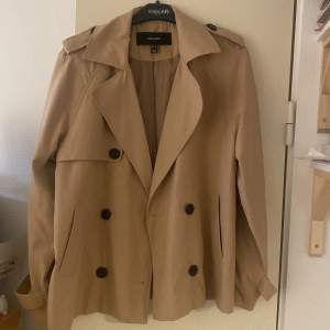 Säljer en snygg beige trenchcoat från veromoda i mycket bra skick. Jackan har en klassisk design med dubbelknäppning och stora knappar. Perfekt för höst och vår, med långa ärmar och stiliga detaljer vid axlarna. Passar både till vardags och lite finare tillfällen. Strl M