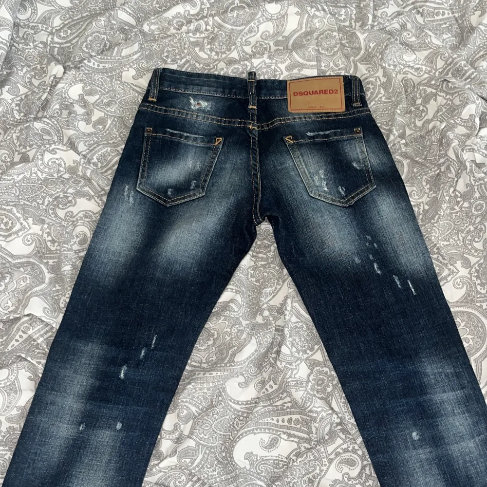 Säljer ett par snygga mörkblå jeans från Dsquared2 i bra skick. De har en cool slitningseffekt och är i en straight stil. Perfekta för en avslappnad look med en touch av edge. Passar bra till både vardag och fest! Det är helt nya . Jeans & Byxor.