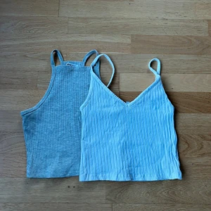 Två ribbade linnen från Gina Tricot och H&M - Säljer två snygga ribbade linnen i storlek XS. Det gråa linnet är från Gina Tricot och det vita från H&M. Tunna axelband och bekväma passform. Båda är i mycket bra skick och passar till både vardag och fest! 🩶