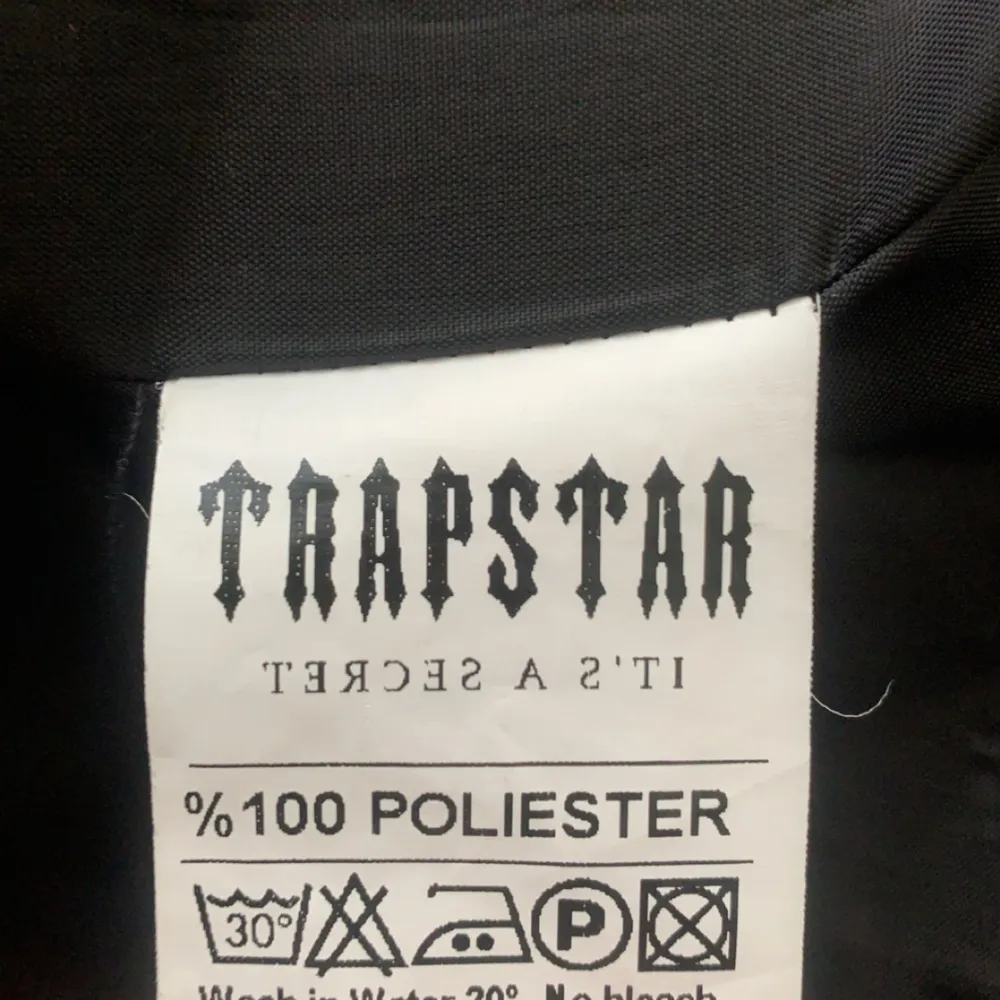 Säljer en svart pufferjacka från Trapstar i mycket bra skick. Jackan är tillverkad i 100% polyester och har en stor huva. Den har en dragkedja framtill och är perfekt för kalla dagar. Trapstar-loggan finns på ryggen i en cool stil. Perfekt för vintern! 🖤. Jackor.