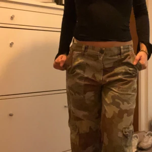 Camouflage cargobyxor - Säljer ett par coola camouflage cargobyxor,använd fåtal gånger. Sitter bra på mig som är 160cm och har en mer lågmidjade passform.