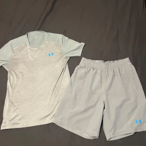 Grå träningsset från Under Armour - Säljer ett grått träningsset från Under Armour . T-shirten är i storlek XS men sitter som S. Setet inkluderar matchande shorts och är i storlek M. Slutsåld i butiker. Nypris 1050 kr.