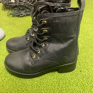 Svarta boots från Dasia - Säljer ett par svarta boots från Dasia i skinn med snörning och dragkedja. De har en robust design med en liten klack och är perfekta för höst och vinter. Skorna är i mycket bra skick och passar både till vardags och lite tuffare outfits.